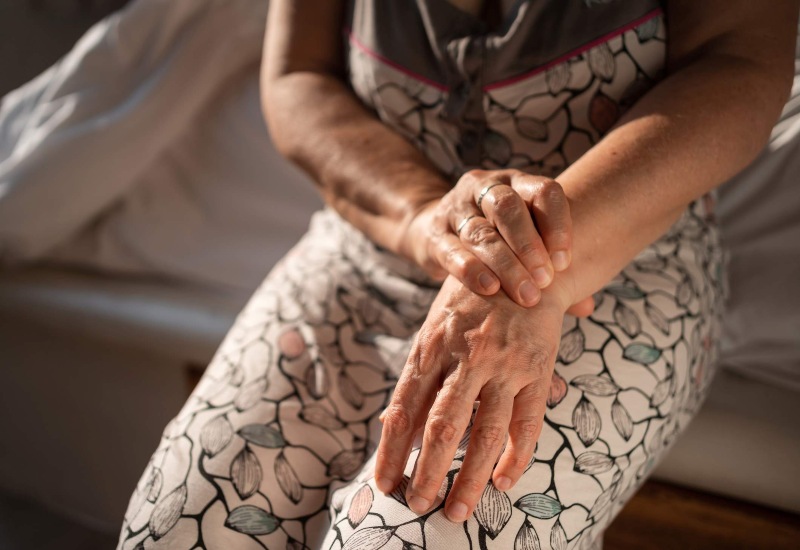 An old woman touching her wrist suffering from e Rheumatoid Arthritis in Maryland