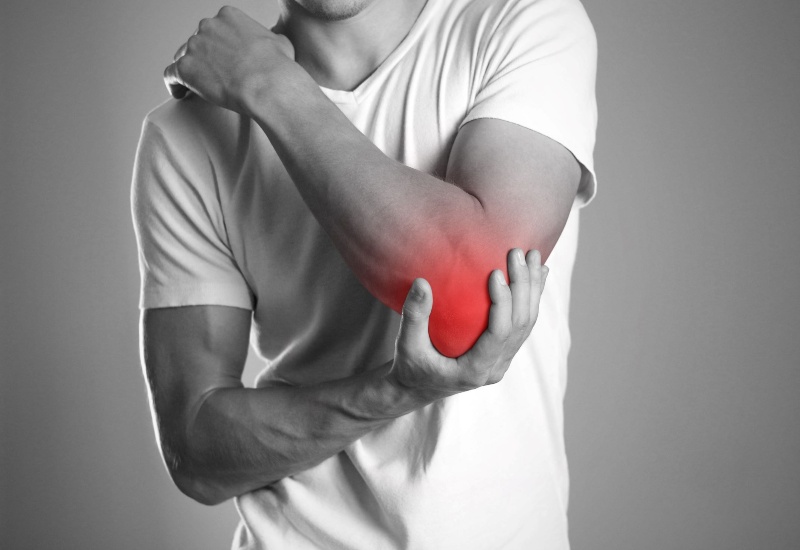 A man is showing his elbow, showcasing the inflammation in his elbow in Maryland