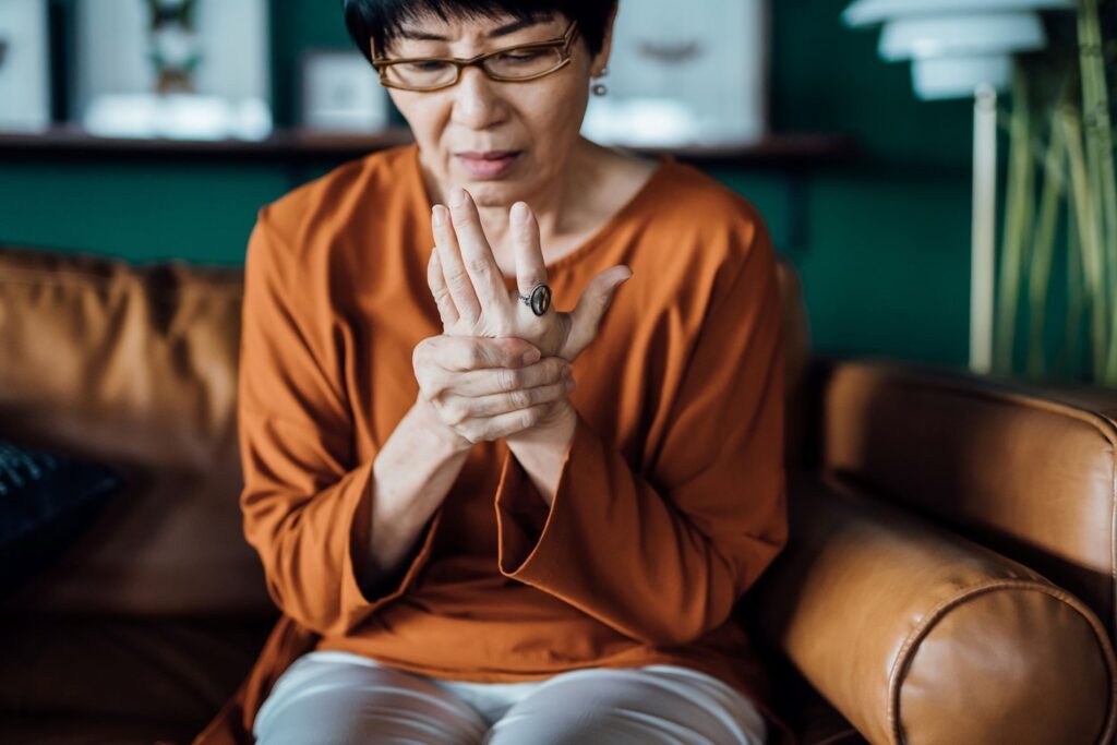 A woman holds her hands to find arthritis relief in her Maryland home