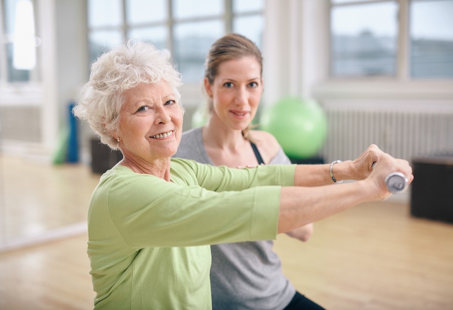 A woman is helping an old lady in streaching exercise in Maryland
