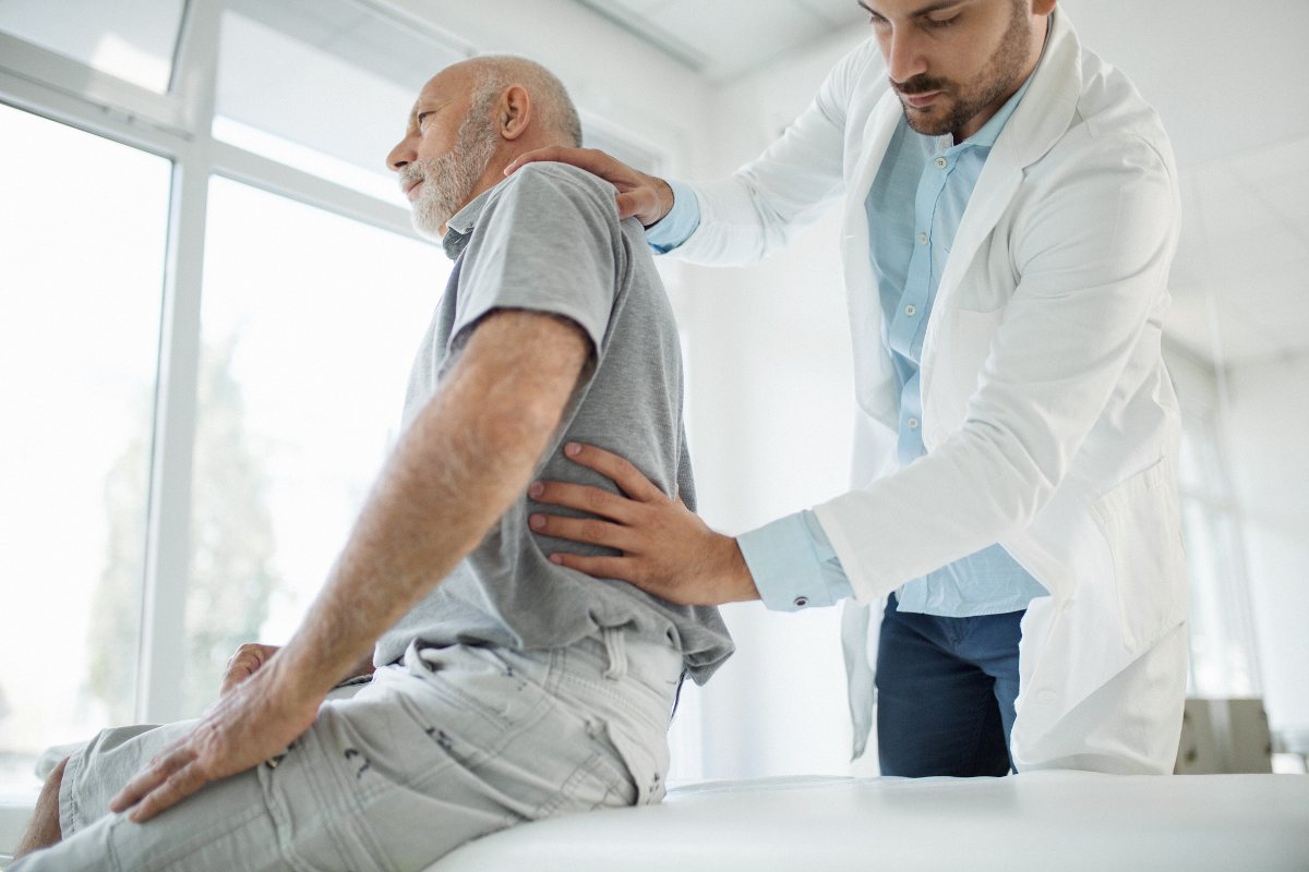 A doctor is checking the lower back of a patient to provide treatment in Maryland