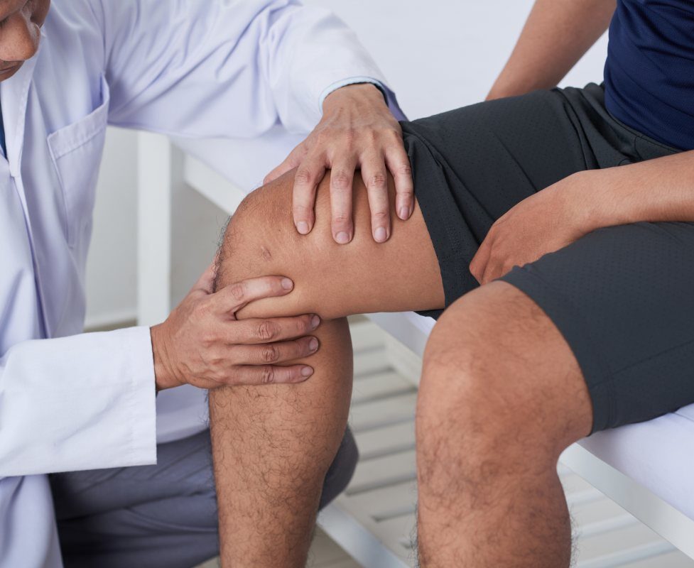 Doctor examining the knee of a patient at his clinic in Greater Maryland