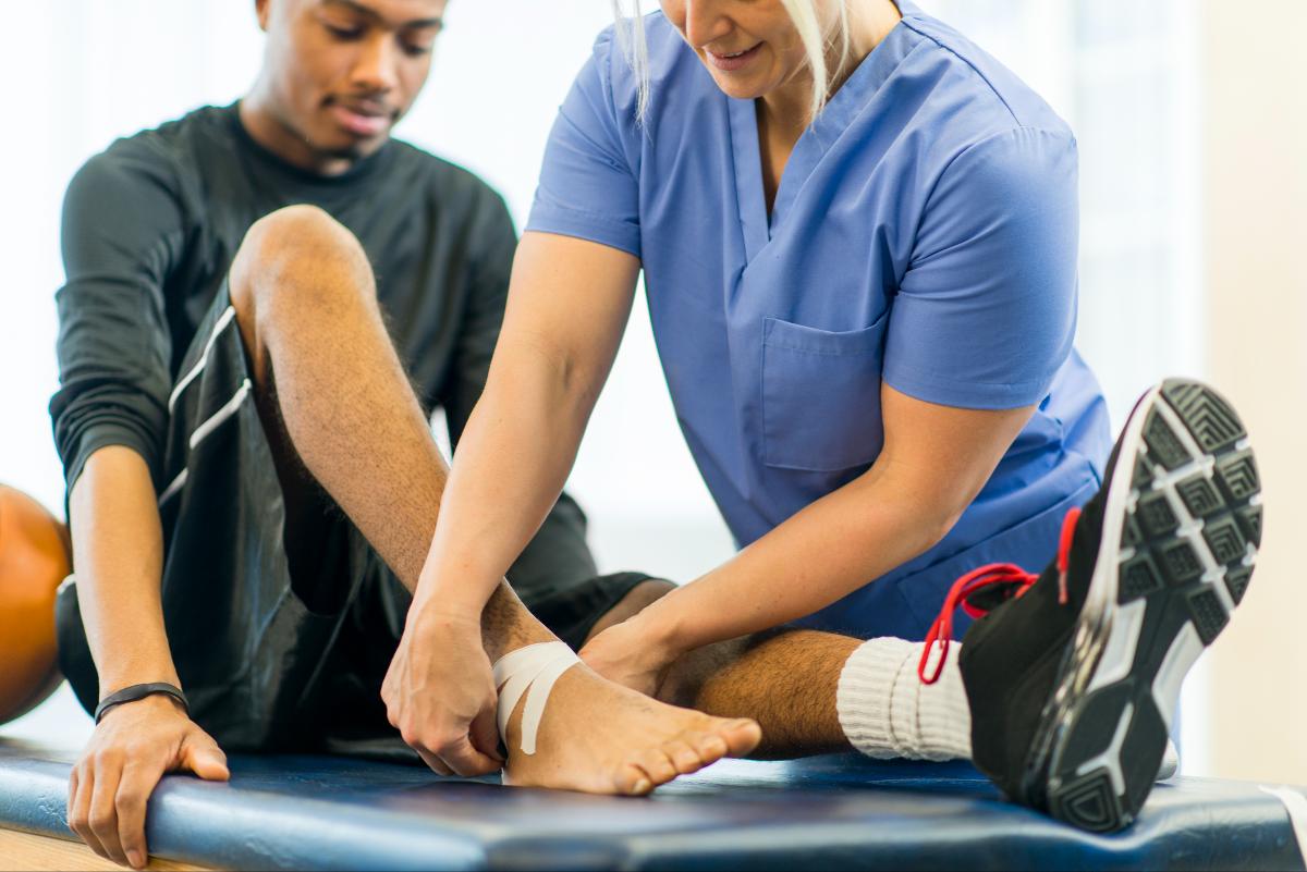 A doctor applying a bandage to a young boy with an ankle injury in Maryland