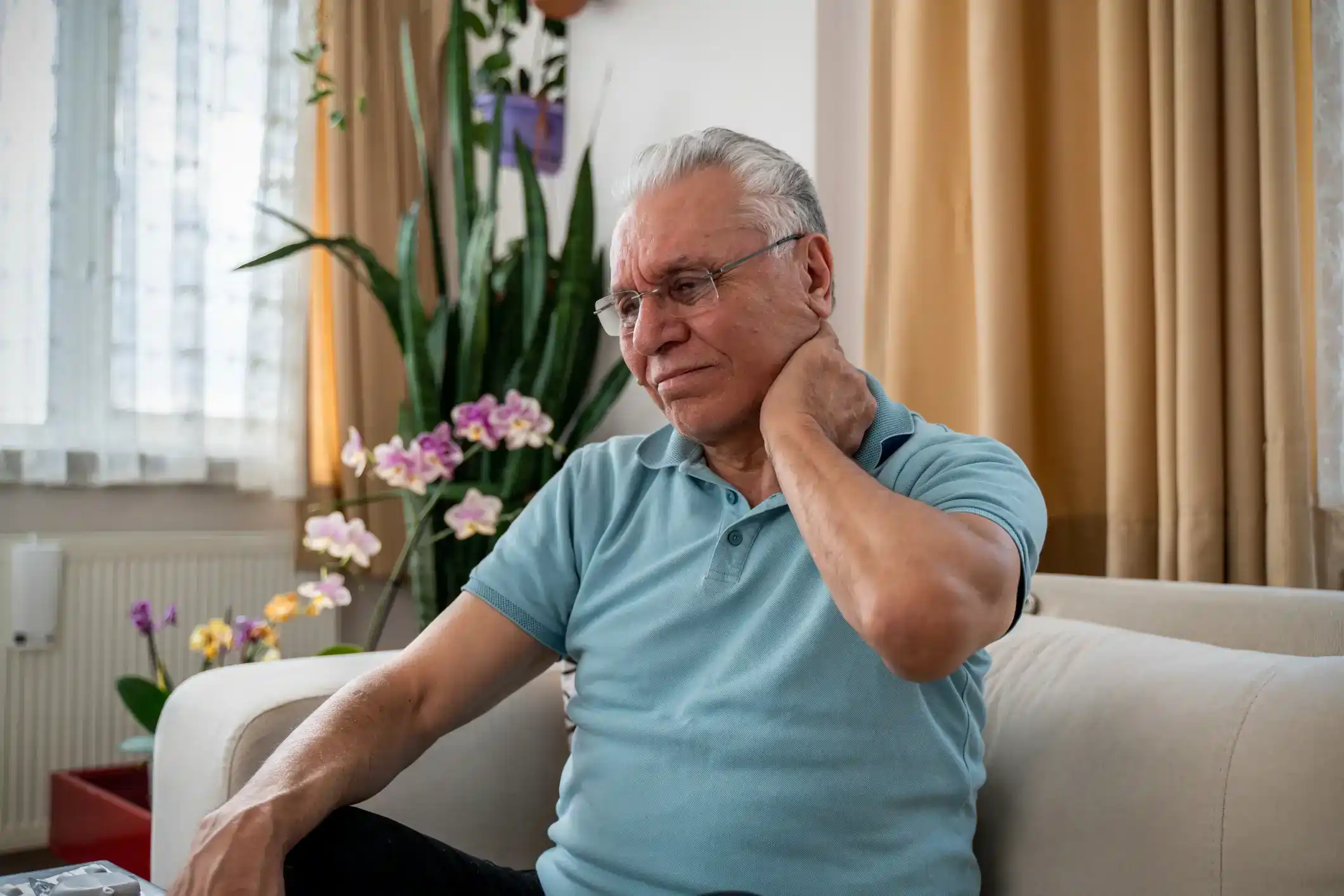 An old man, holding his neck, is suffering from fibromyalgia pain in Maryland
