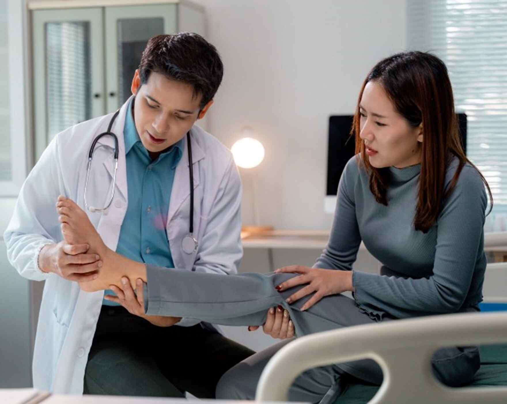 Doctor examining the ankle of a female patient at a hospital in Maryland