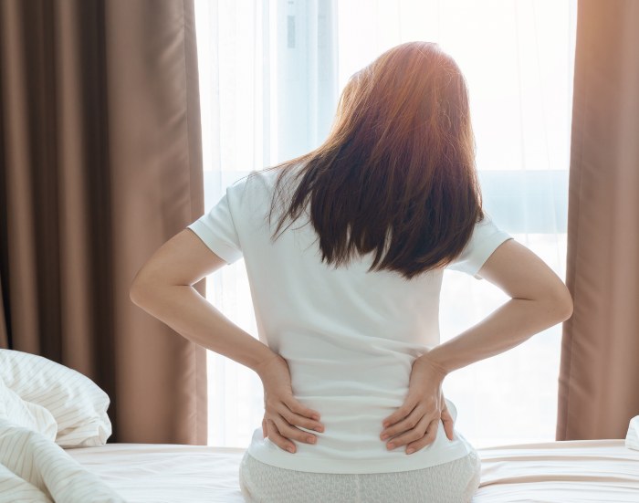 woman sitting on bed facing lower back pain in Greater Maryland