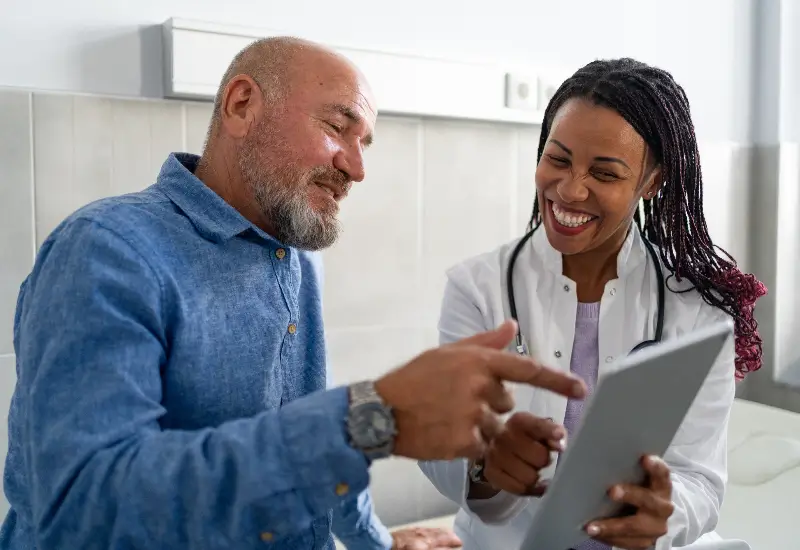 A pain management specialist reviews notes with a patient in Maryland
