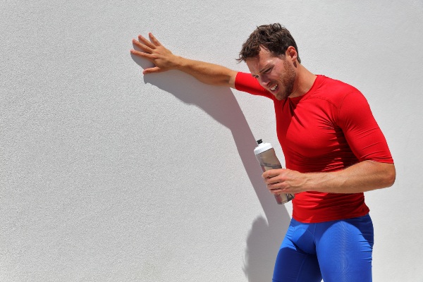 Tired, dehydrated man drinking water after workout 