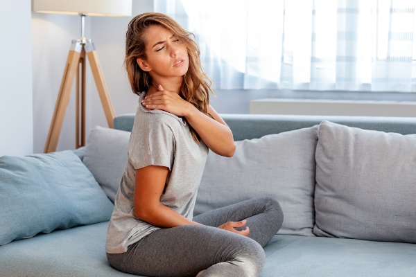 Woman with shoulder pain sitting on couch
