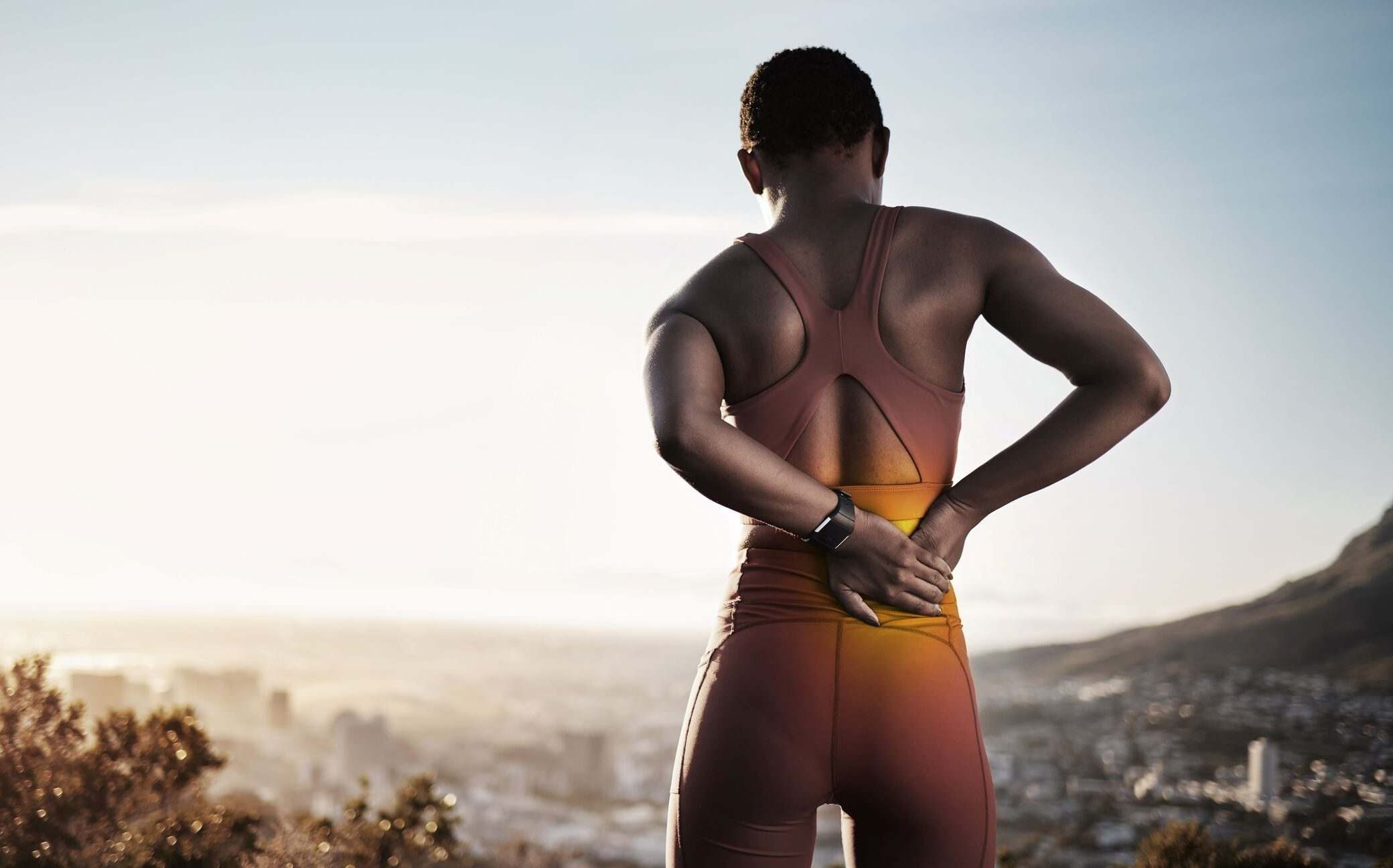A woman showing signs of back pain, highlighting back pain relief and treatment in Maryland