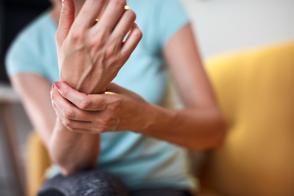 Woman with wrist tendonitis holding her hand in pain