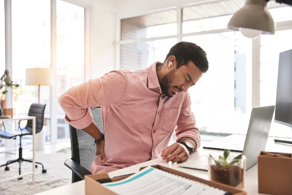 Man with chronic back pain sitting at desk