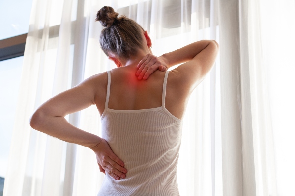 Woman with pinched nerve clutching neck and back in pain