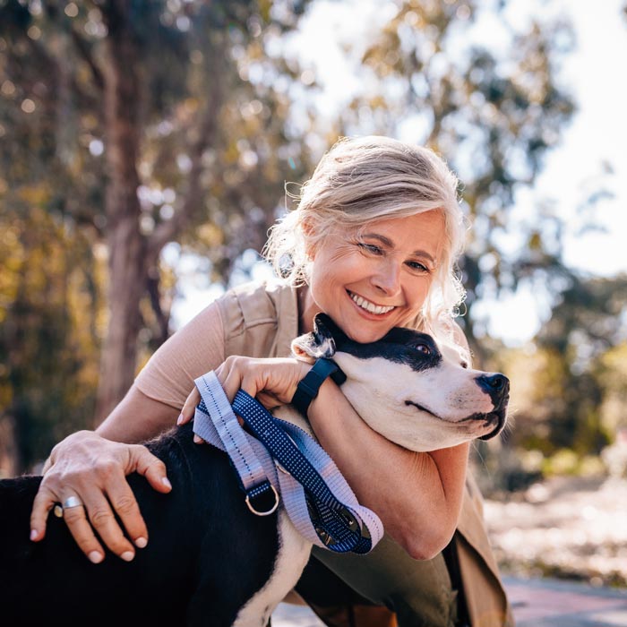 A woman can walk her dog in a park after a successful pain relief treatment in Maryland