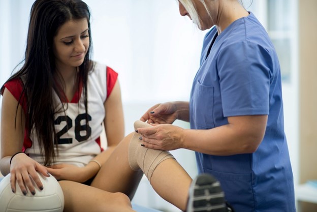 A young volleyball player from Maryland gets medical treatment for her knee injury during her match.