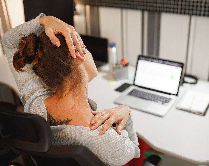 Woman facing neck pain due to long working hours on laptop in Maryland